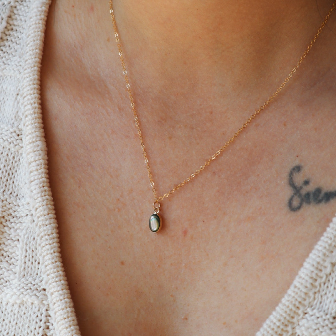 model wearing 14k gold fill delicate chain necklace with abalone pendant 