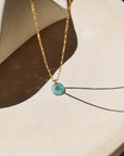 Amazonite donut shaped gemstone pendant attached to a 14k gold Fill chain in the sunlight