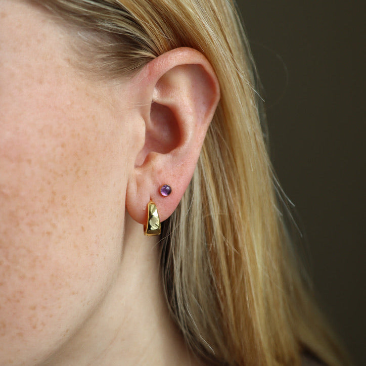 model wearing 14k gold fill huggie hoop earrings with studs with round amethyst stones