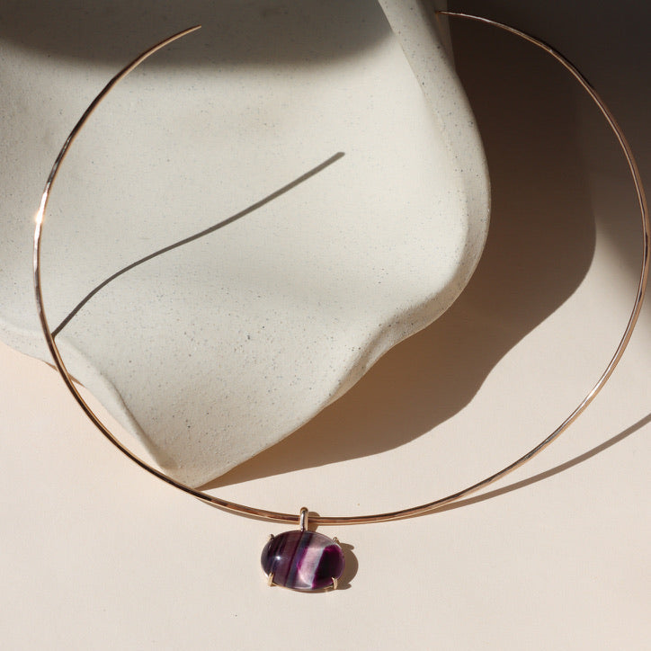 14k gold fill wire collarbone necklace with handset fluorite stone in a bezel on a light dish