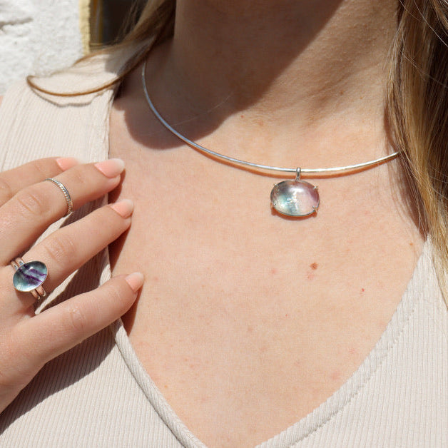 model wearing sterling silver wire collarbone necklace with handset fluorite stone in a bezel with other sterling silver and gemstone jewelry