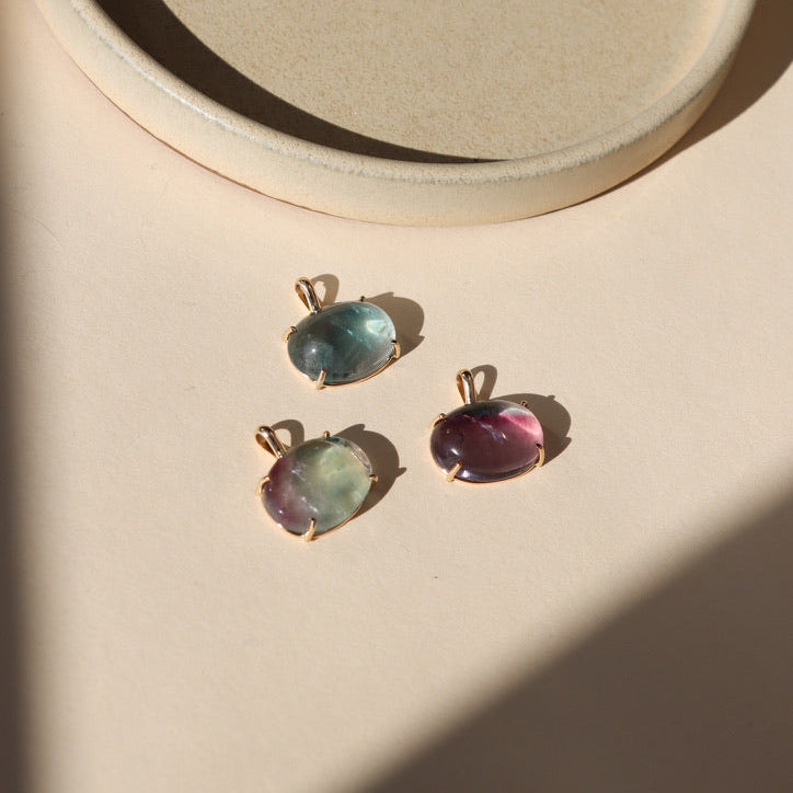 14k gold fill bezel pendants with oval fluorite cabs on a light dish