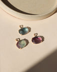 14k gold fill bezel pendants with oval fluorite cabs on a light dish