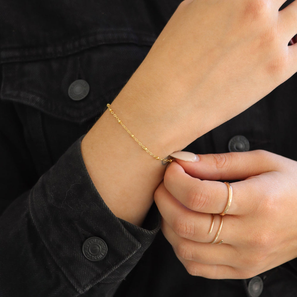 model wearing 14k gold fill beaded chain bracelet in the sunlight