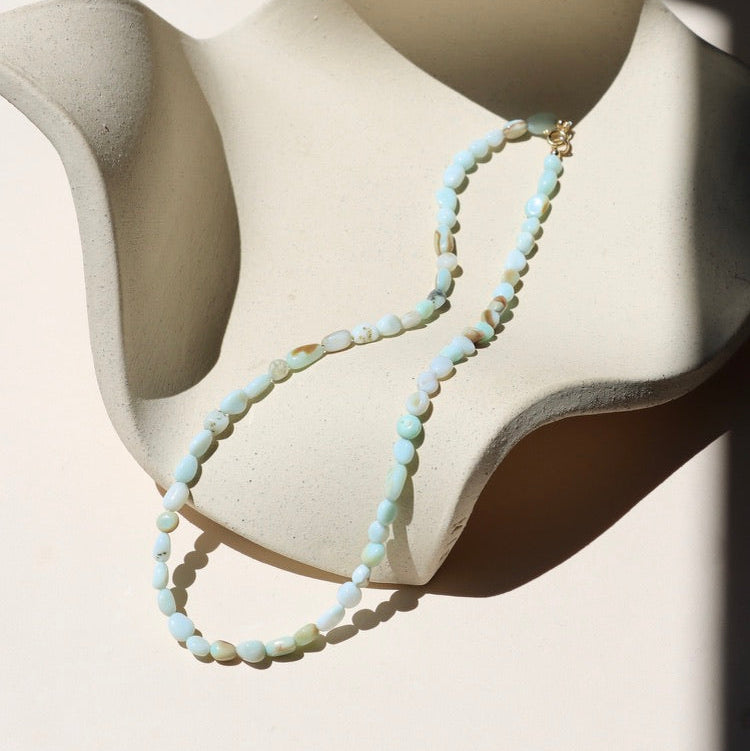 oval blue opal beaded necklace on a light surface