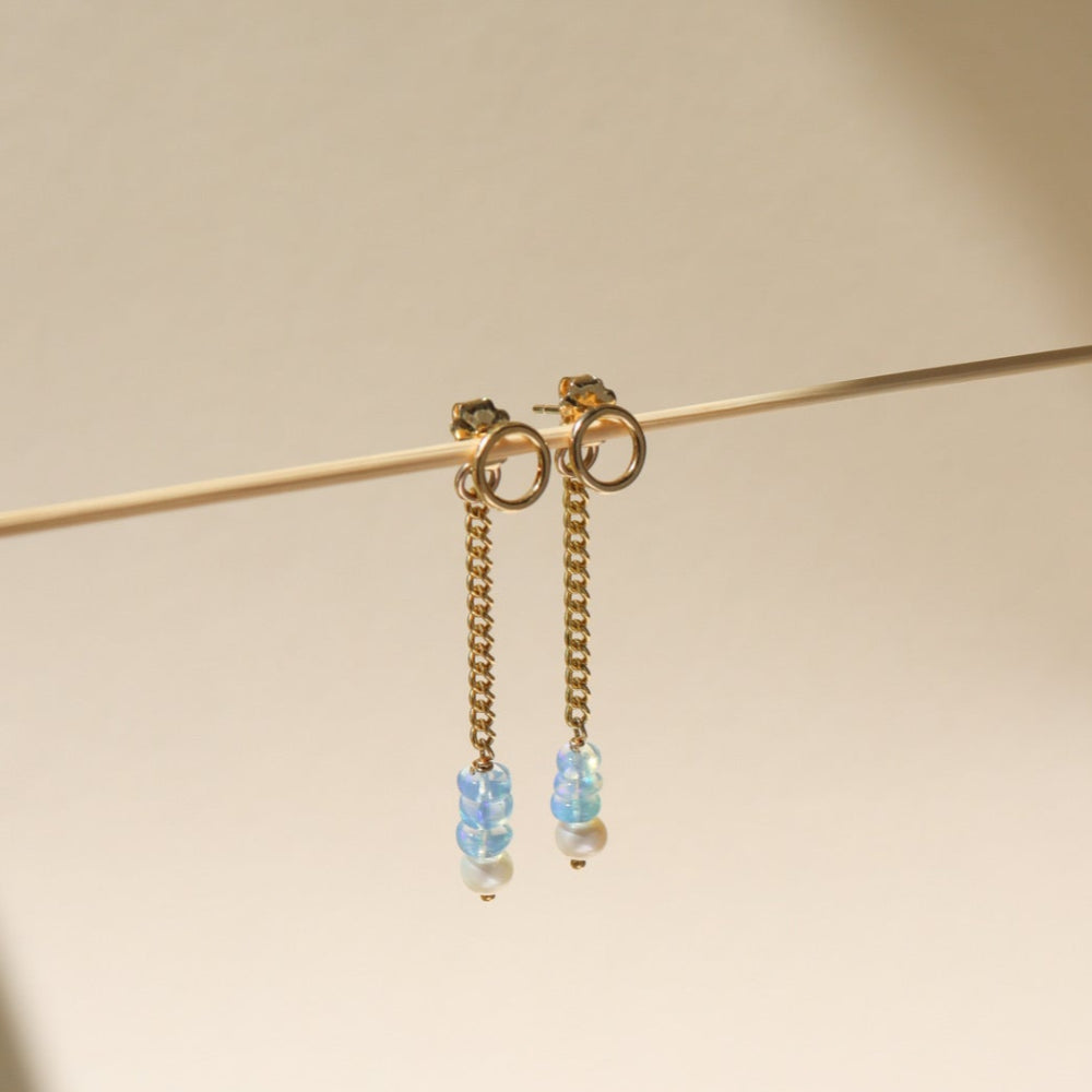 A 14k gold fill back drop with a dainty curb chain, with three opal gemstones and one mini pearl set at the bottom