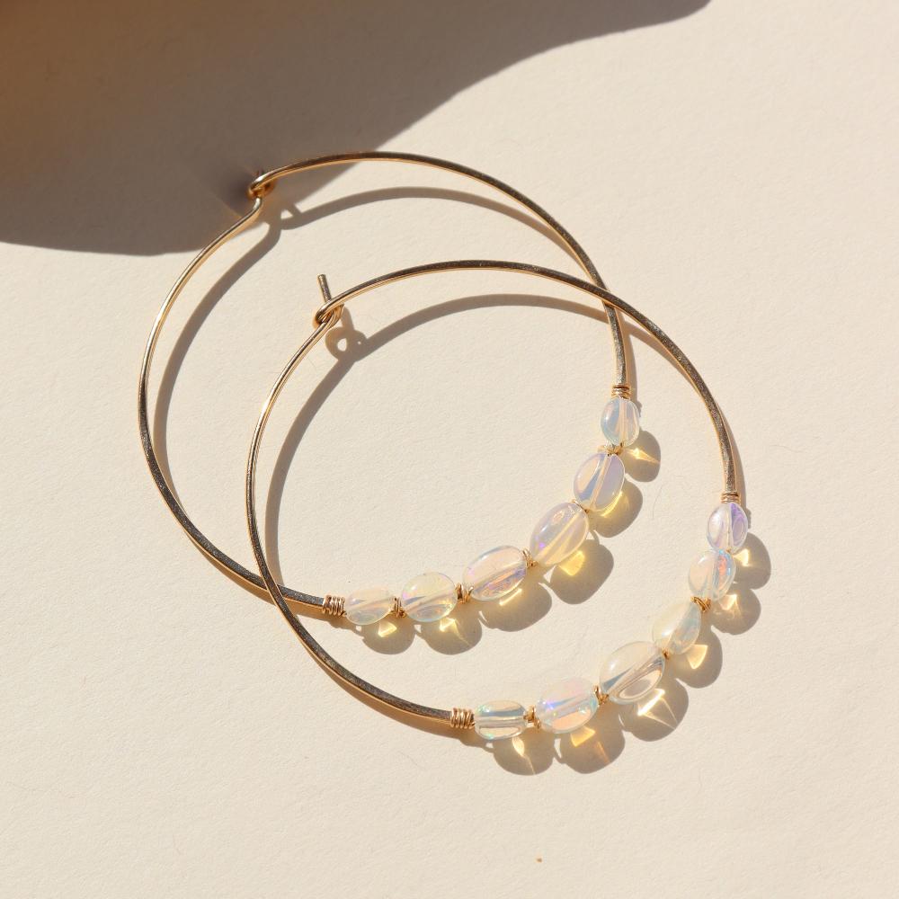 14k gold fill or sterling silver hoops, handmade and lightly hammered for shine, then adorned with six genuine australian opals that are delicately wire-wrapped. Handmade by Token Jewelry in Eau Claire, WI