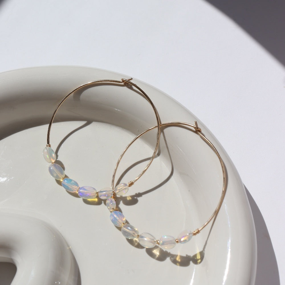 14k gold fill or sterling silver hoops, handmade and lightly hammered for shine, then adorned with six genuine australian opals that are delicately wire-wrapped. Handmade by Token Jewelry in Eau Claire, WI