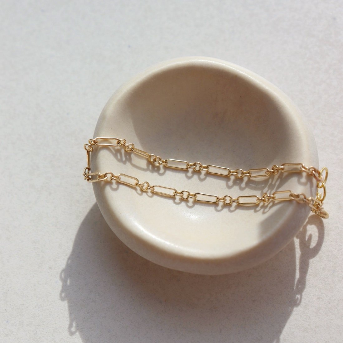 Callie Bracelet by token jewelry on a white ring dish