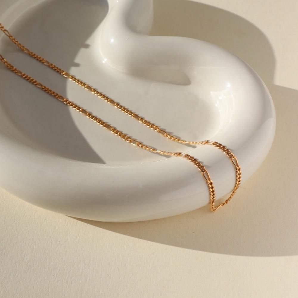 14k gold fill figaro chain necklace on a light dish