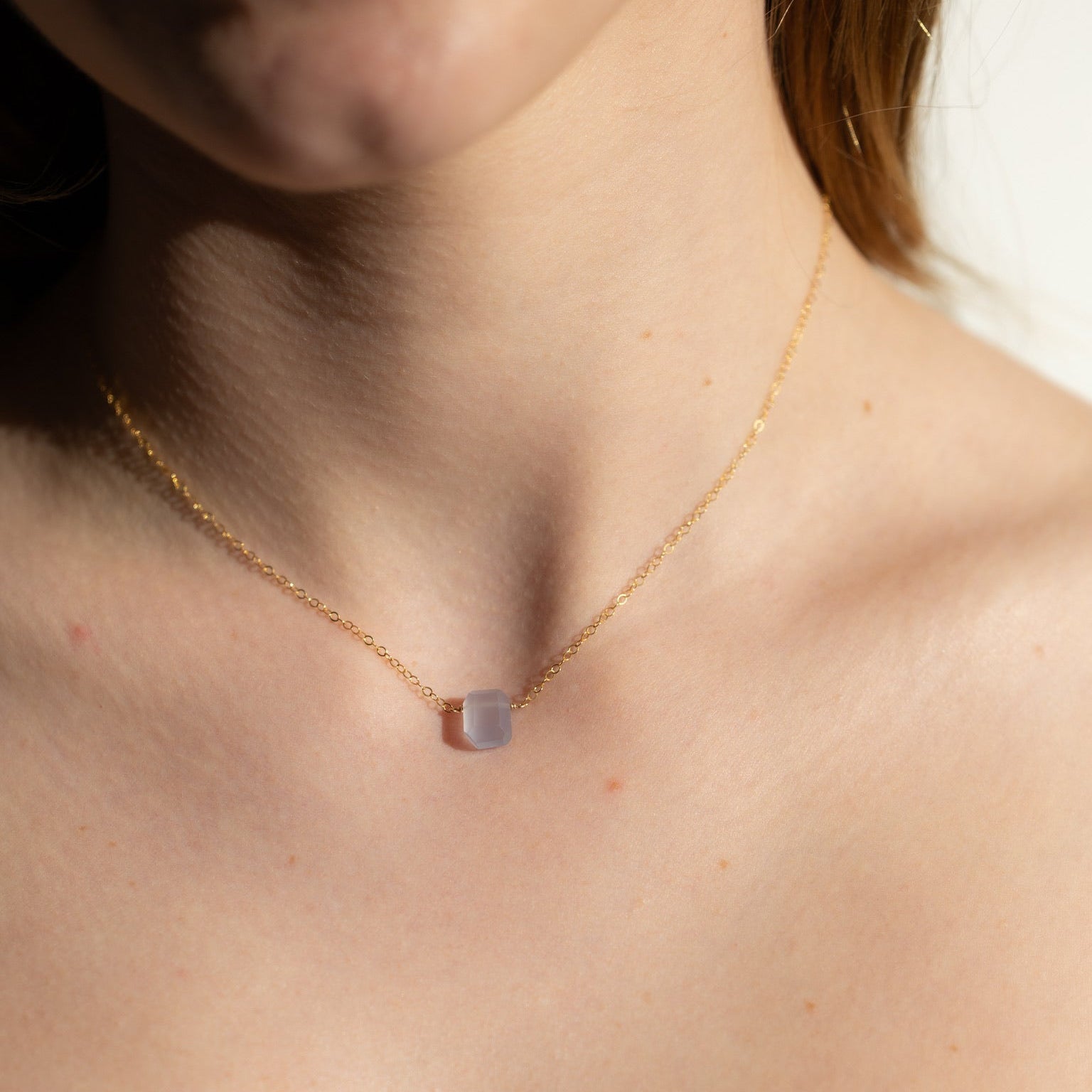 model wearing 14k gold fill delicate chain necklace with chalcedony stone