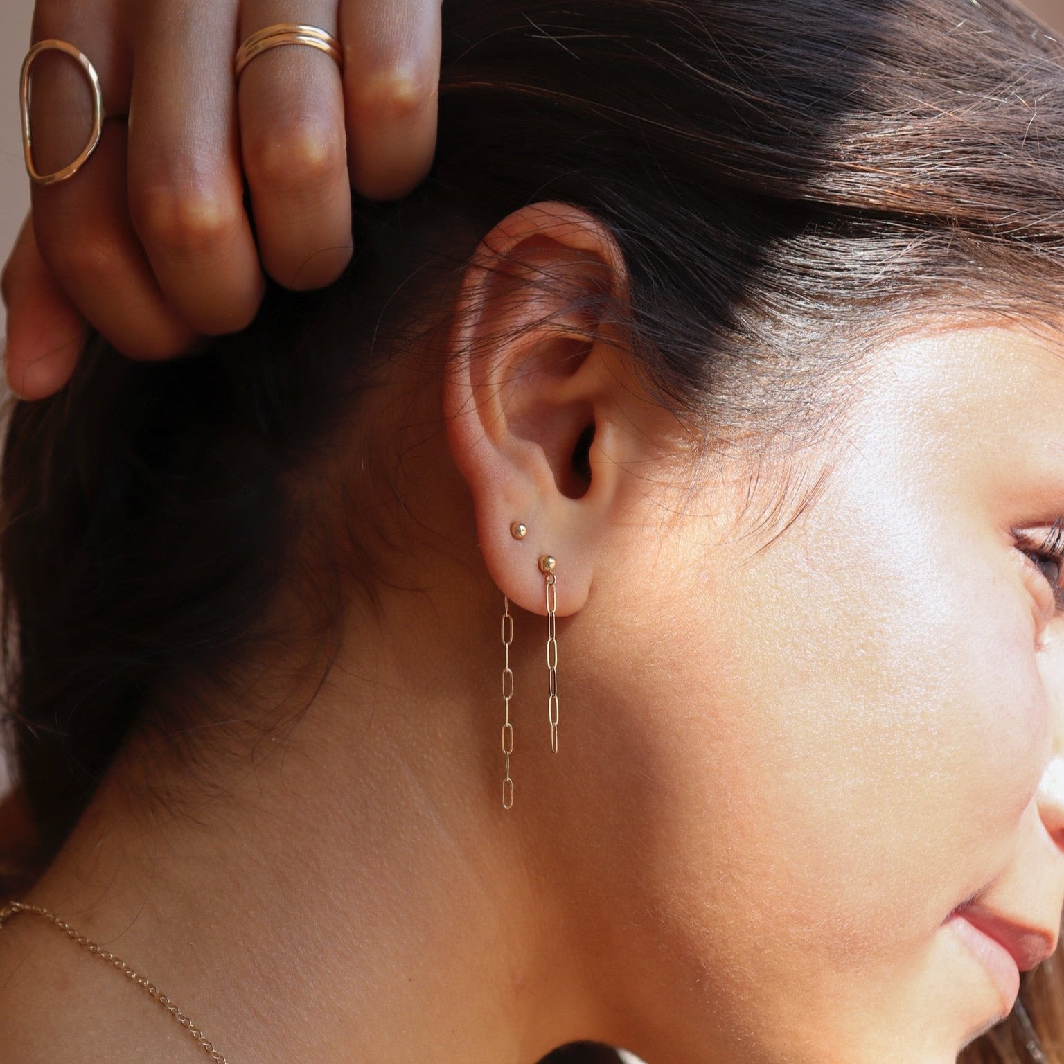 model wearing 14k solid gold stud earrings paired with 14k gold fill chain stud earrings