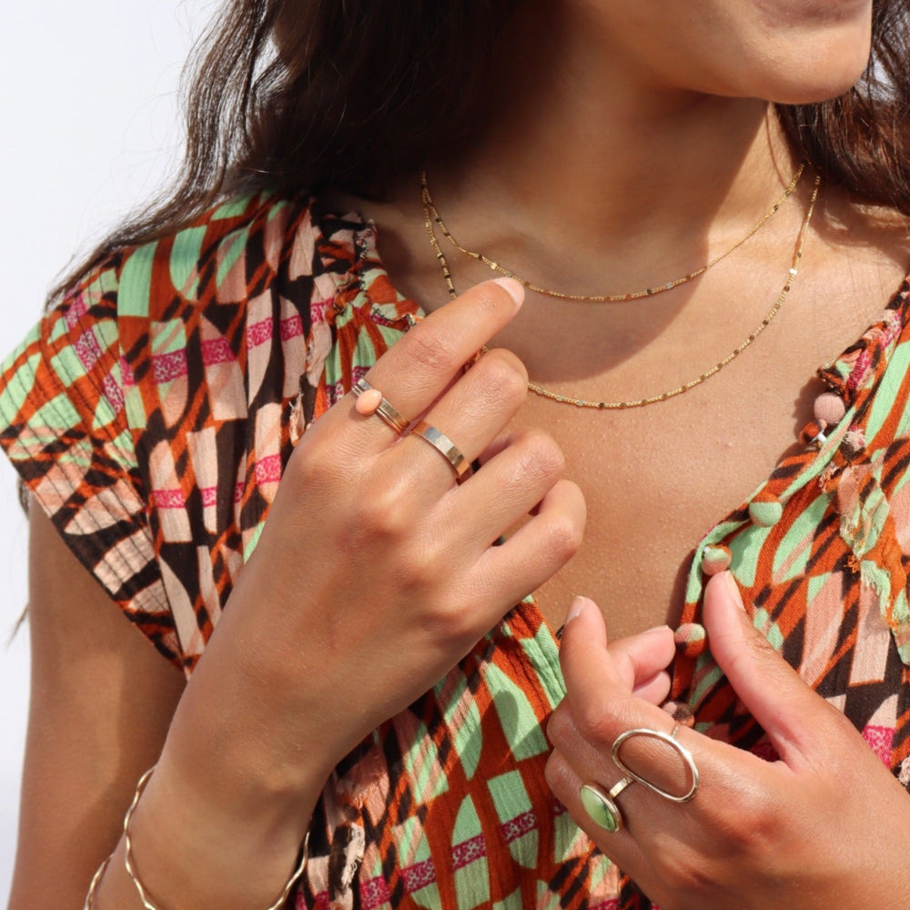 Model wearing a coral gemstone ring set in a 14k gold fill bezel