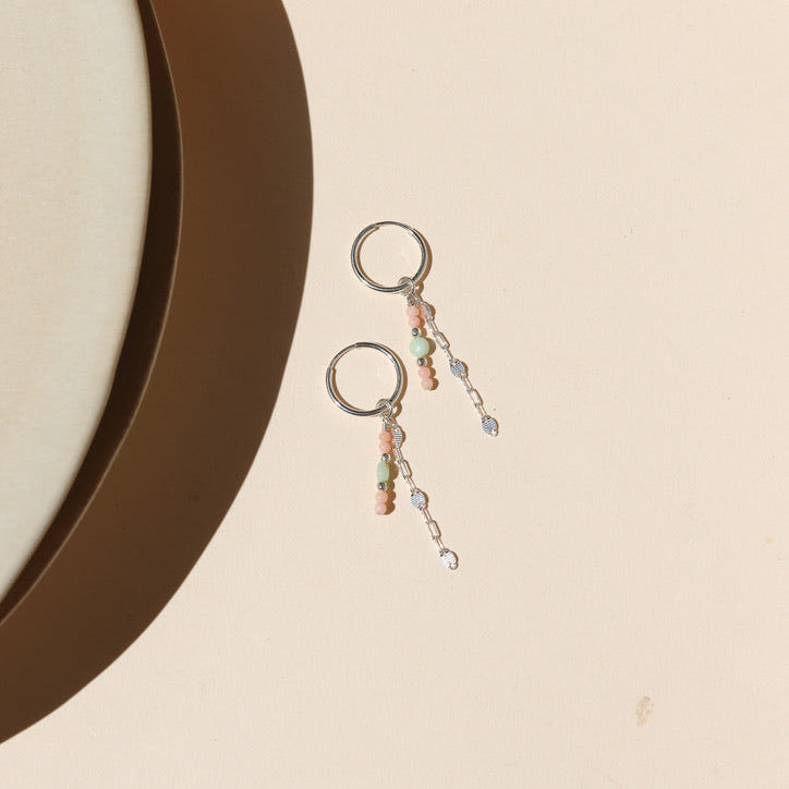 sterling silver hoops with sparkly chain and chrysoprase and coral beads on a light surface