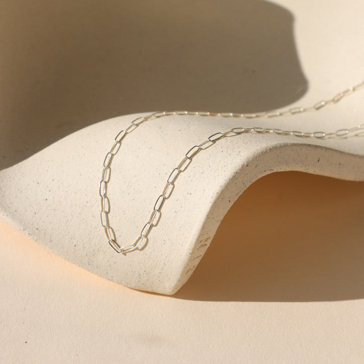 sterling silver paperclip chain on a light dish