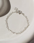 925 sterling silver heart link chain in children's sizes, photographed on a ceramic white plate