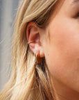 Model Wearing 14k gold fill Mini Echo Studs paired with a spiral ear cuff.