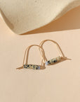 14k gold fill arch shaped earrings with dalmatian jasper & blue lace agate beads on a light background