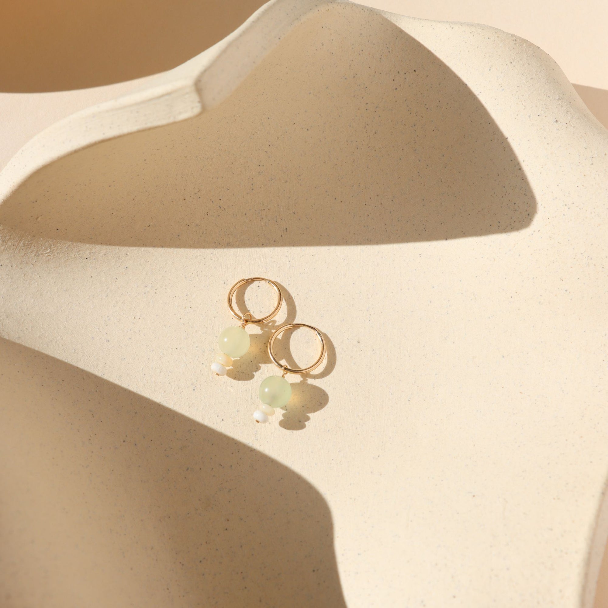 14k gold fill hoops with chalcedony and ethiopian opal beads on a light dish
