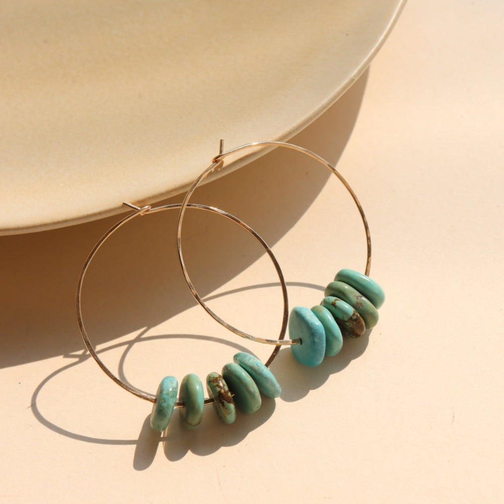Desert Sky Hoops featuring hammered gold filled with teal green turquoise bead accents.