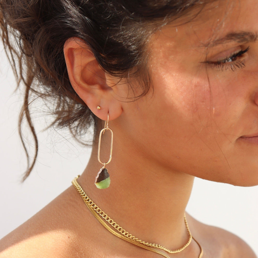 Model wearing a 14k gold fill drop earring with a chrysophrase gemstone wire wrapped at the bottom