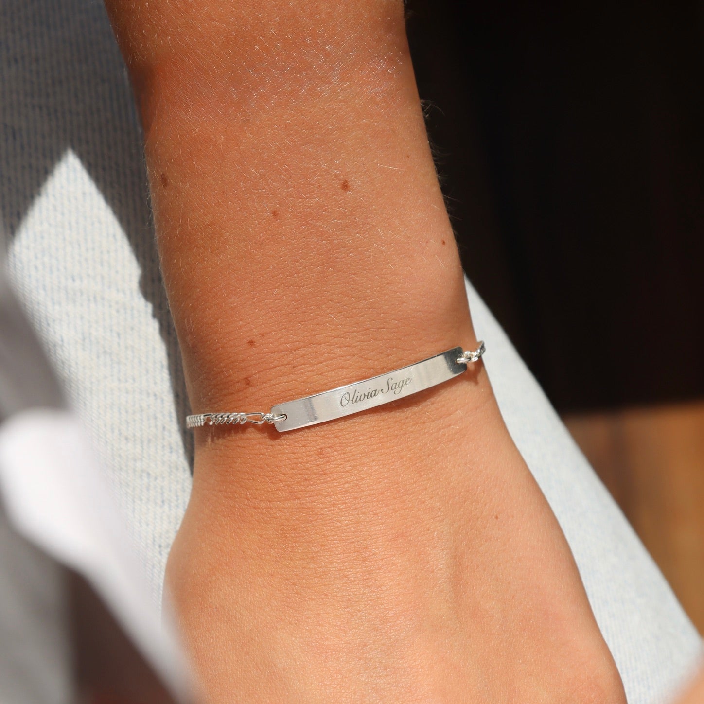 model wearing sterling silver chain and bar bracelet with custom engraving on bar