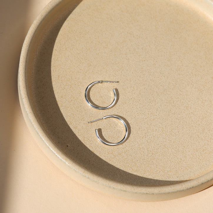 sterling silver hammered hoop earrings on a light dish
