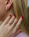 Close-up of model wearing 14k gold fill textured earrings with 14k gold fill textured and hammered rings 