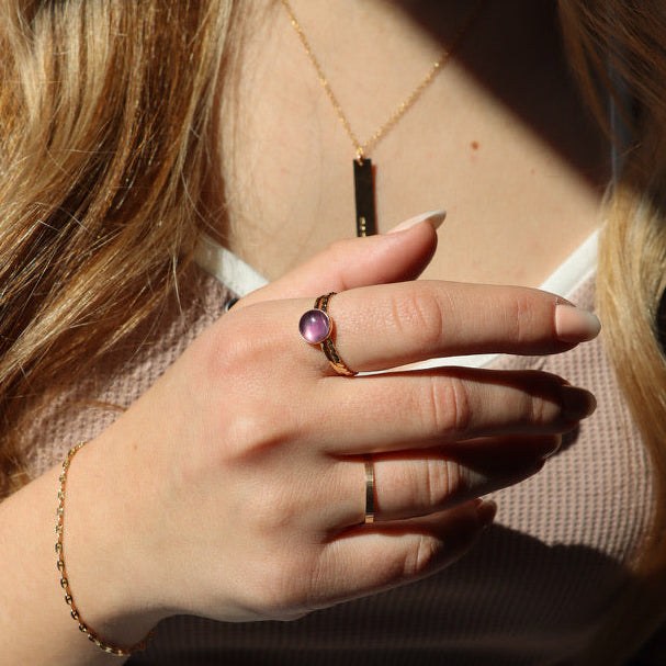 model wearing 14k gold fill ring with round fluorite stone paired with other 14k gold fill jewelry