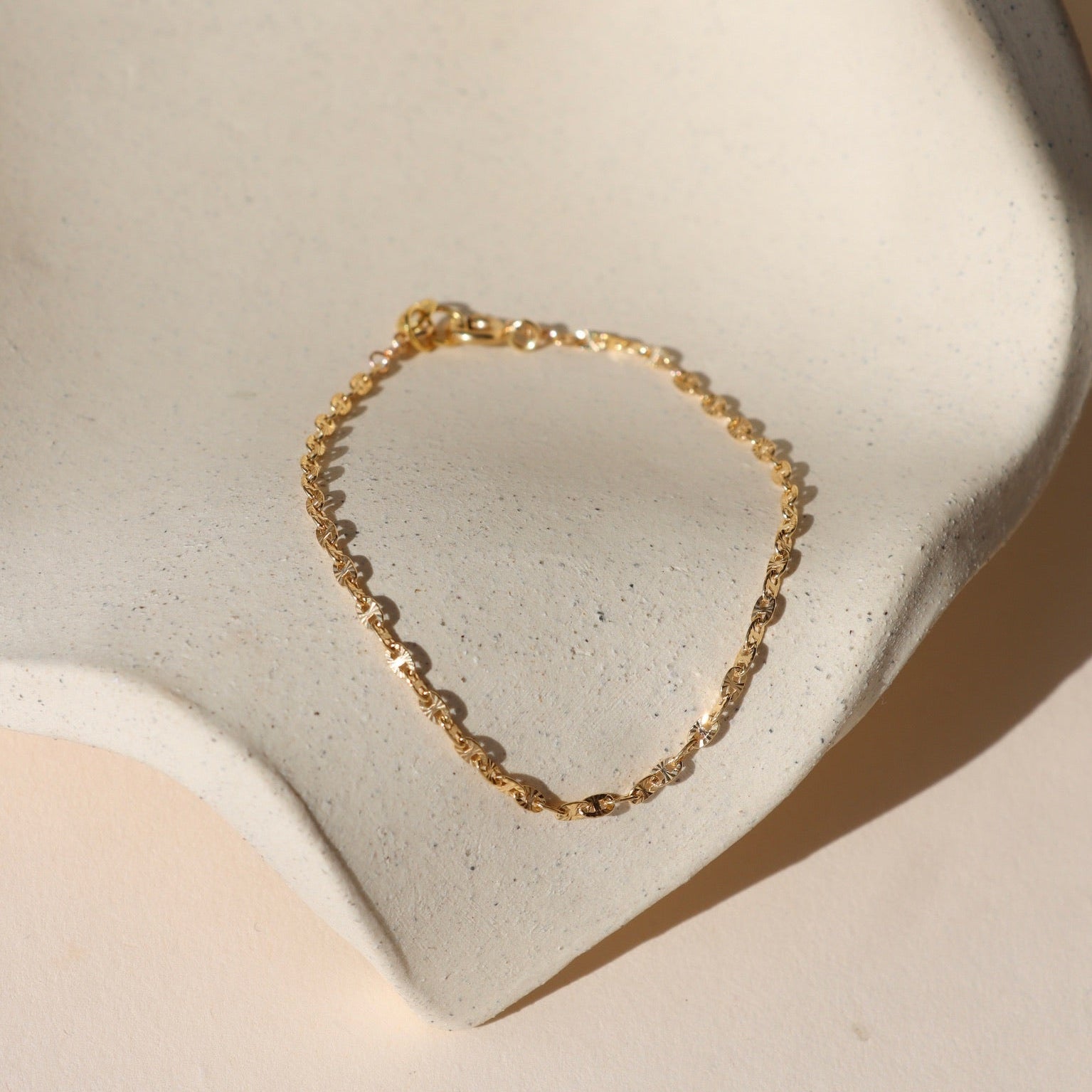 14k gold fill chain bracelet on a light dish