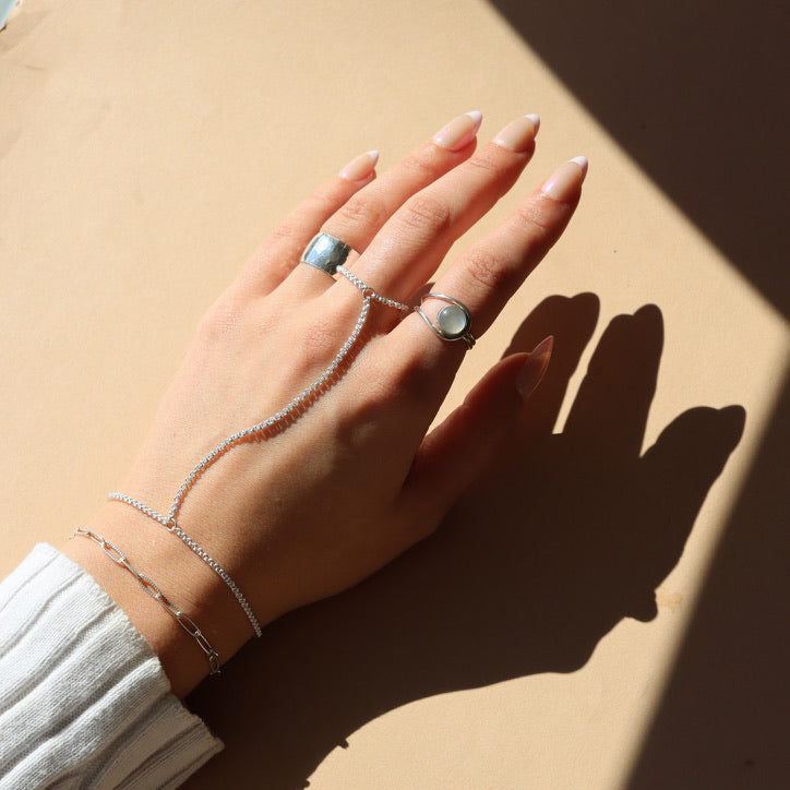 Model wearing sterling silver hand chain in the sunlight