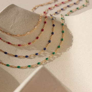enamel stones in 14k gold fill chain on light background with shadows