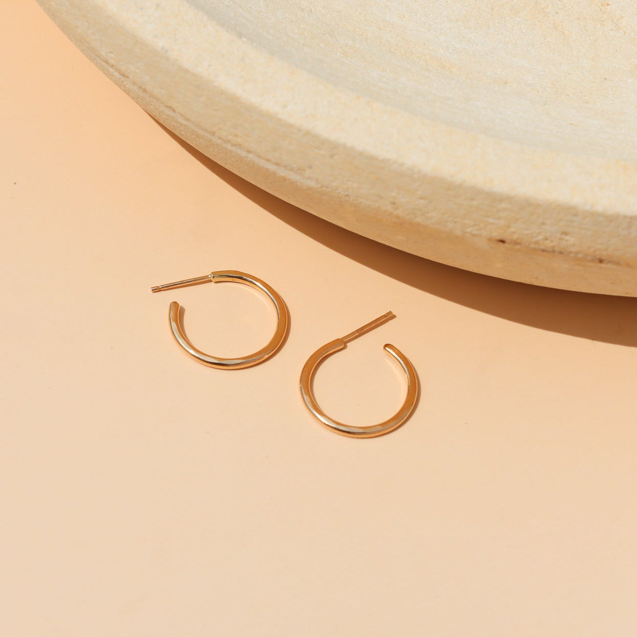 14k Gold Fill Fine Line Hoop Earrings featuring a textured minimalist design, lightweight everyday hoop earrings displayed on a ceramic jewelry tray in warm natural light.