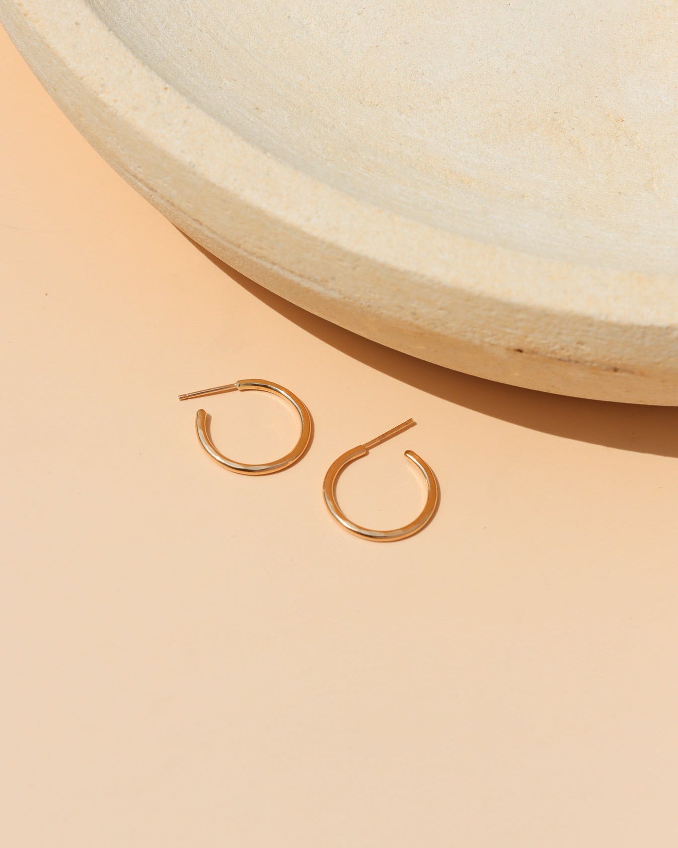 14k Gold Fill Fine Line Hoop Earrings featuring a textured minimalist design, lightweight everyday hoop earrings displayed on a ceramic jewelry tray in warm natural light.