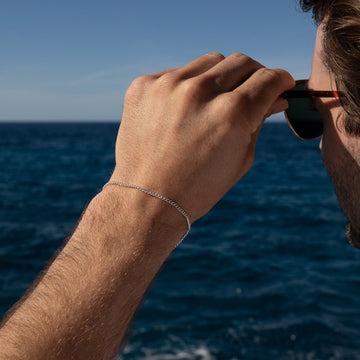 Model wearing La mer Bracelet in 925 sterling silver. next to the ocean.