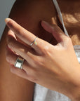 Model wearing a sterling silver hammered band with a kyanite gemstones freely hanging from the band. 
