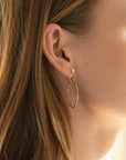 model wearing handmade drop earrings with pearl studs and hand crafted circles