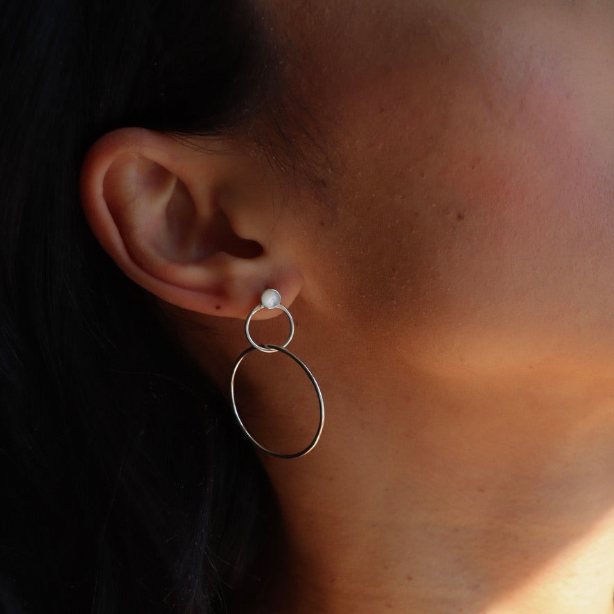 model wearing handmade drop earrings with pearl studs and hand crafted circles