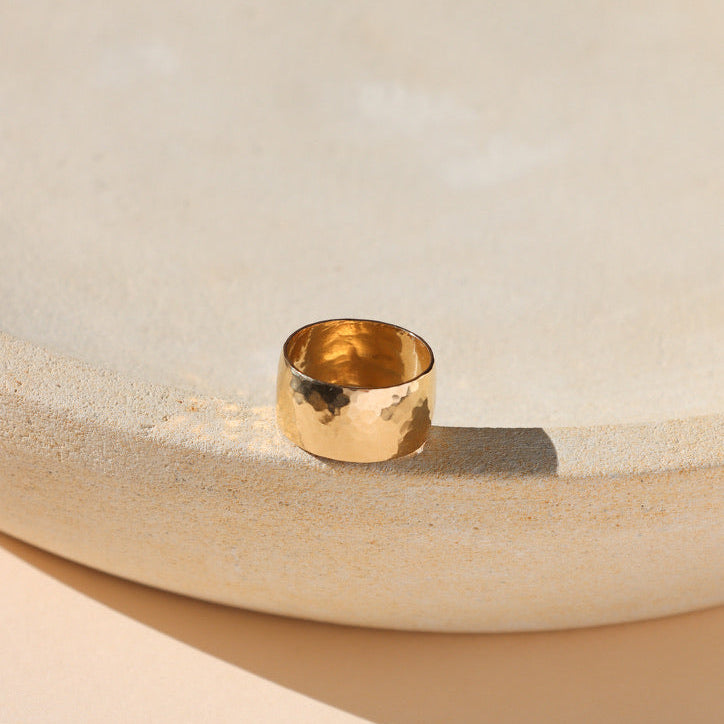 14k gold fill textured thick band ring on a light dish