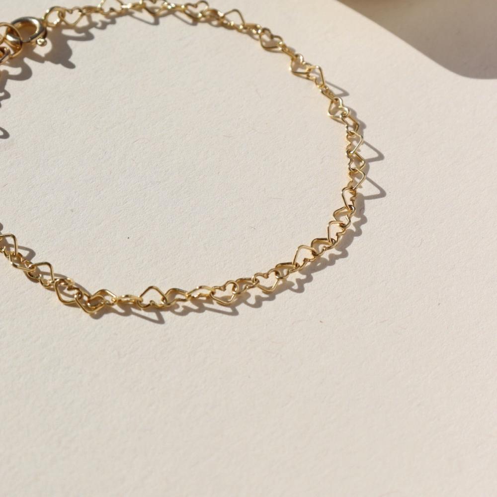 14k gold fill linked heart chain bracelet on a sunny backdrop