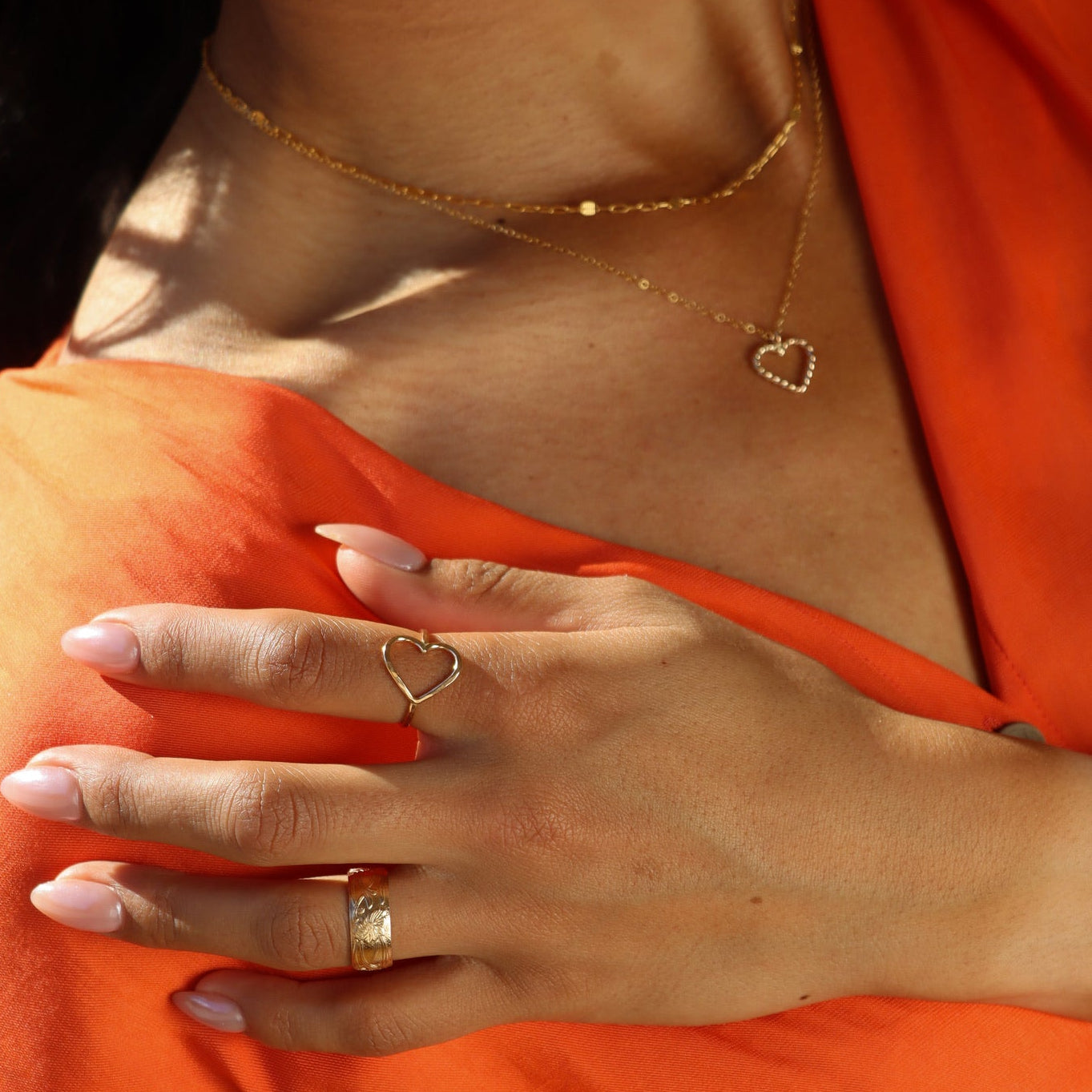 model wearing 14k gold fill heart shaped ring paired with other valentines day jewelry