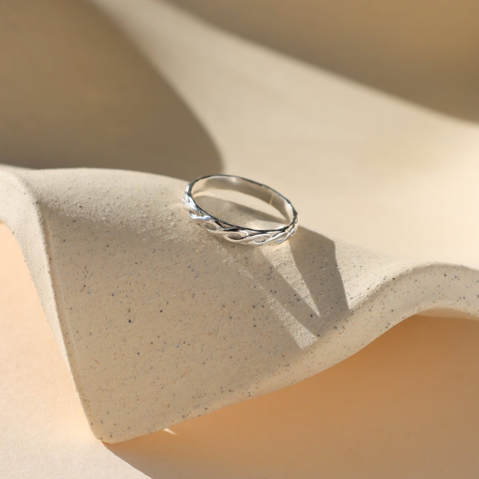 sterling silver textured ring on a light dish