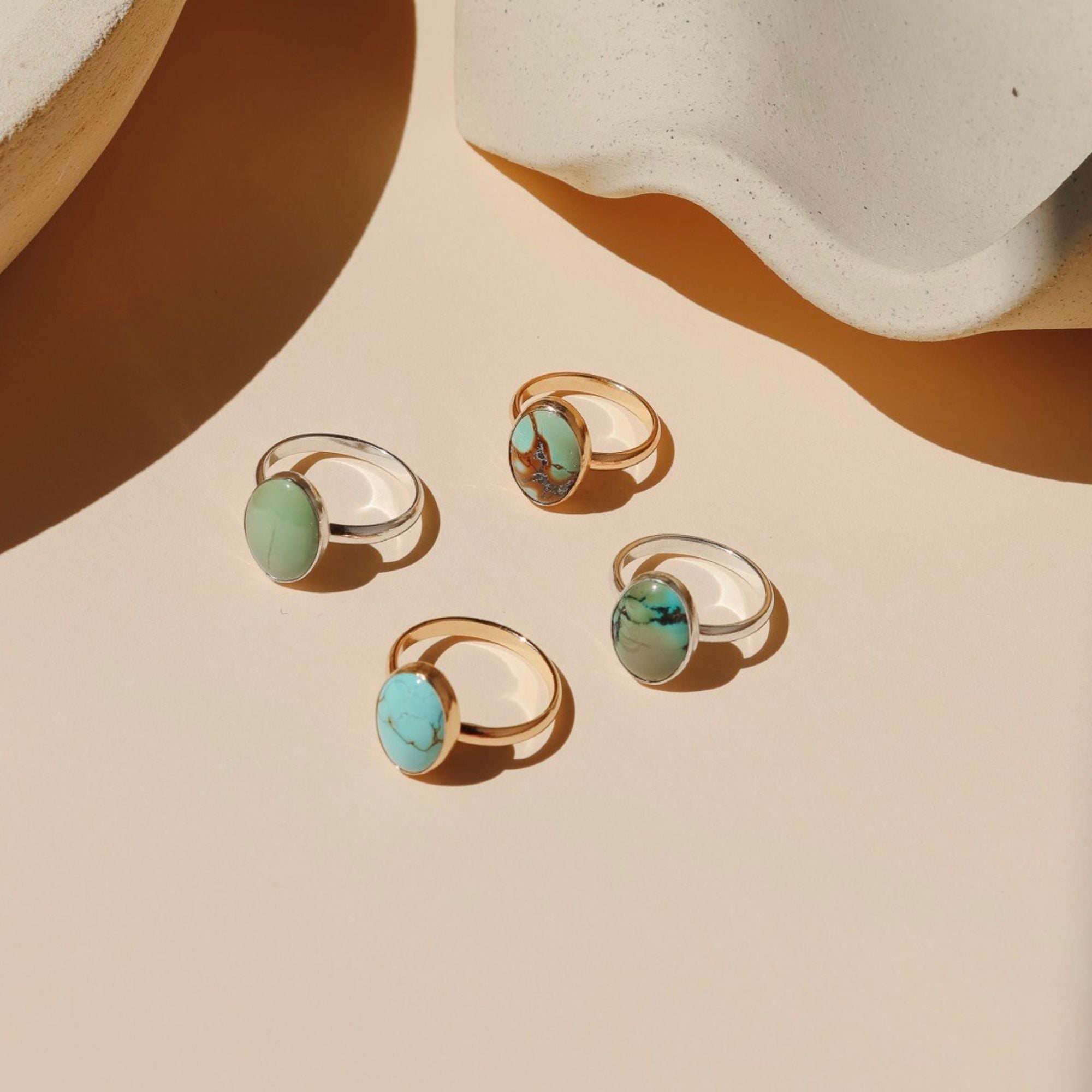 sterling silver and 14k gold fill rings with oval turquoise gemstones in the sunlight