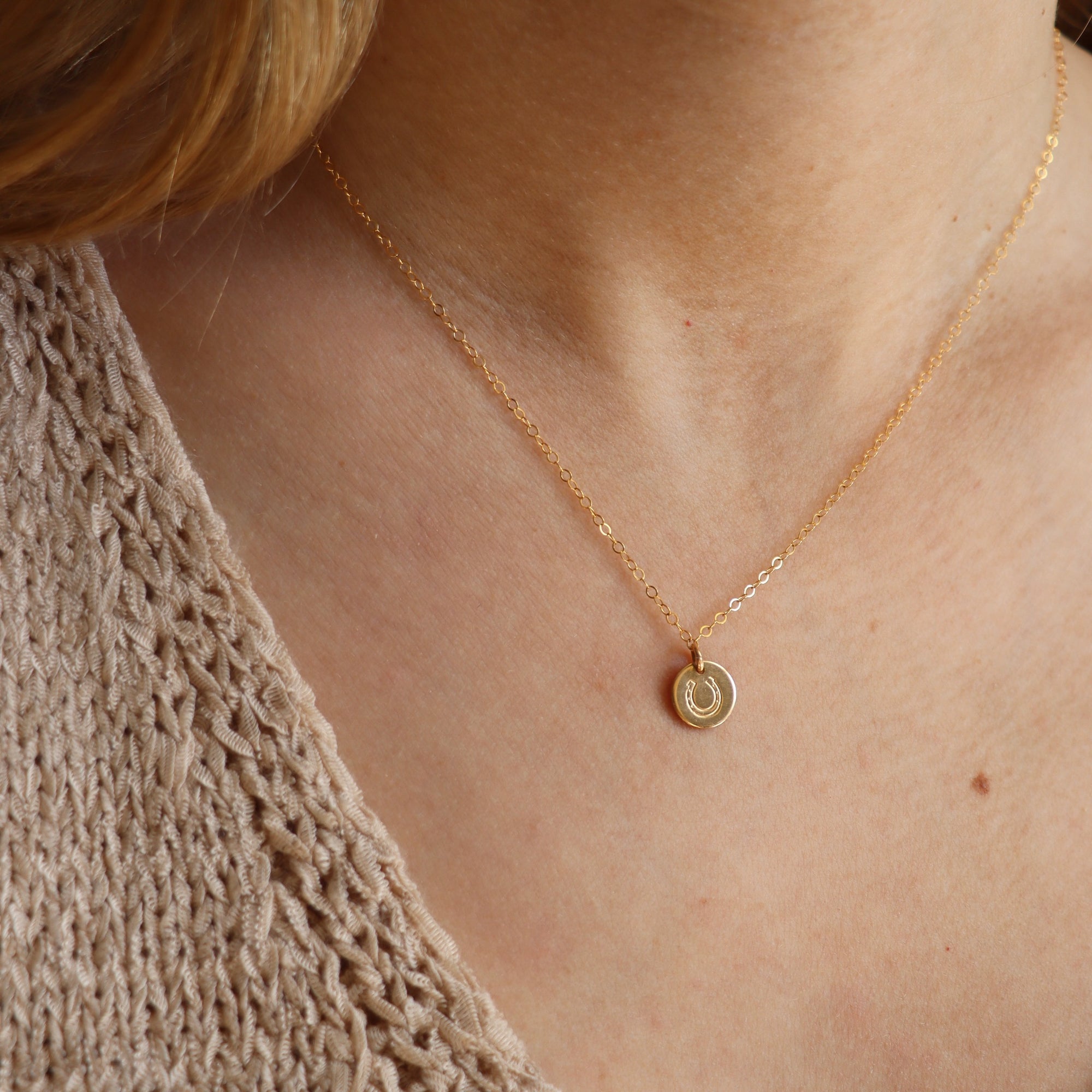 model wearing 14k gold fill disk with horseshoe stamp on a delicate chain necklace 