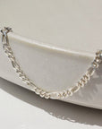 925 Sterling silver Figaro chain anklet placed on a ceramic bowl