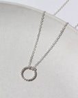 925 Sterling silver Spiral Necklace laid on a white plate. This necklace features the simple chain with the spiral eternity disc.