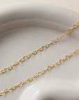 delicate gold fill heart chain necklace, photographed on a ceramic dish