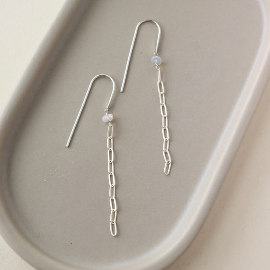 925 sterling silver chain earrings featuring a small pearl on a hook-style earring, photographed on a sunlit table