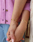 Mother and daughter holding hands and wearing matching 14k gold filled starlight bracelets