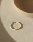 14k gold fill Spiral Ring placed on a white paper in the sunlight. This ring features a simple spiral band making it perfect for stacking.